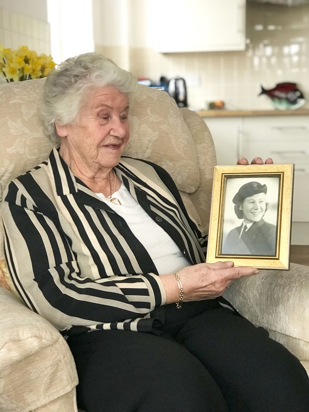 Joyce looking at a photo of her younger self