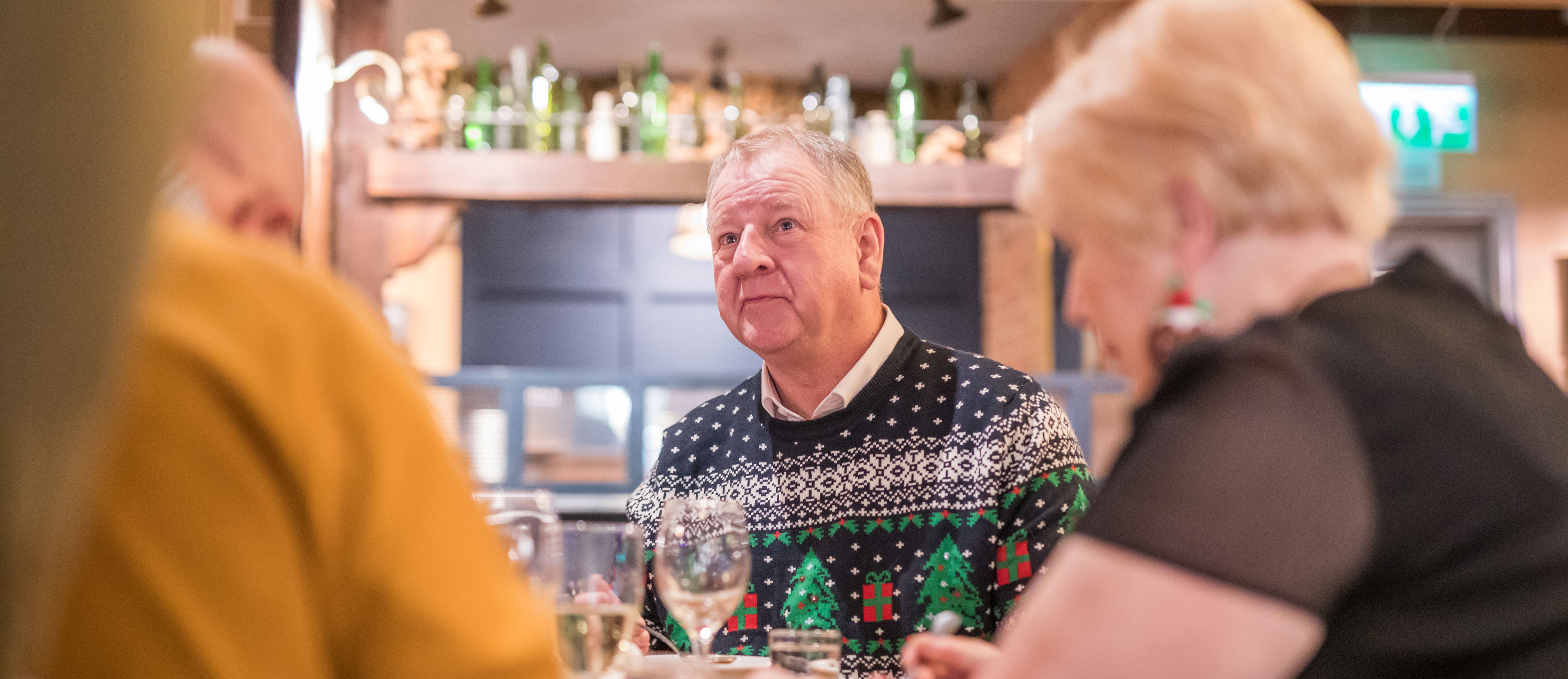 Gentleman conversing with friends over Christmas lunch